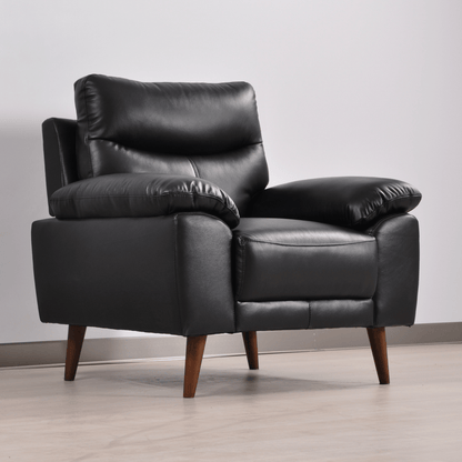 Vantage black armchair in a modern living room set, angled view with decor and soft ambient lighting.
