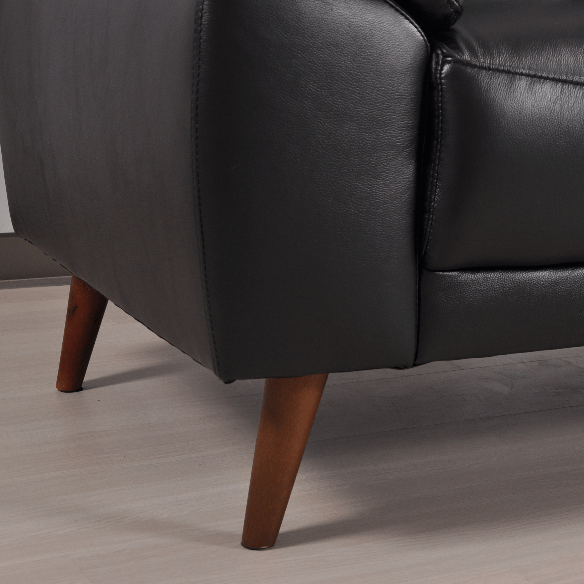 Vantage 2-seater black sofa close-up, highlighting texture, stitching, and modern design details.