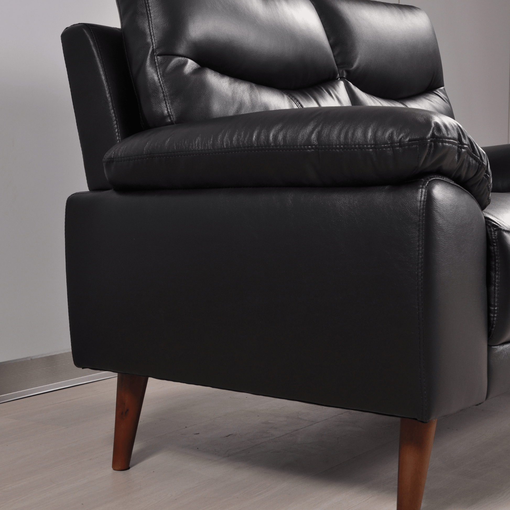 Close-up of Vantage black 2-seater sofa showing plush cushions, soft fabric, and detailed stitching