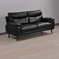 Vantage black 3-seater sofa at an angle in a modern living room with neutral decor and soft lighting
