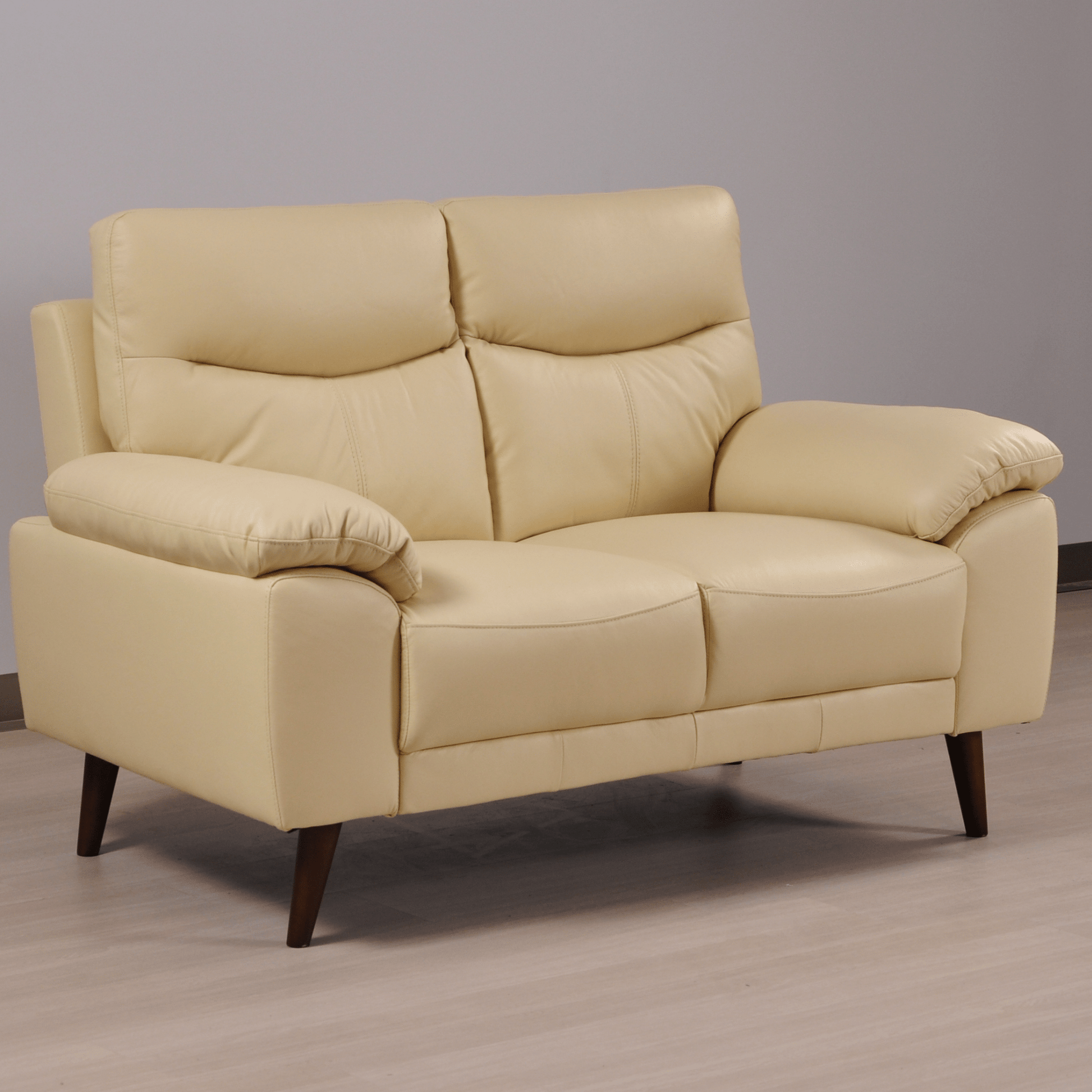 Vantage Cream 2-seater sofa in styled living room, angled view, modern and cozy seating arrangement