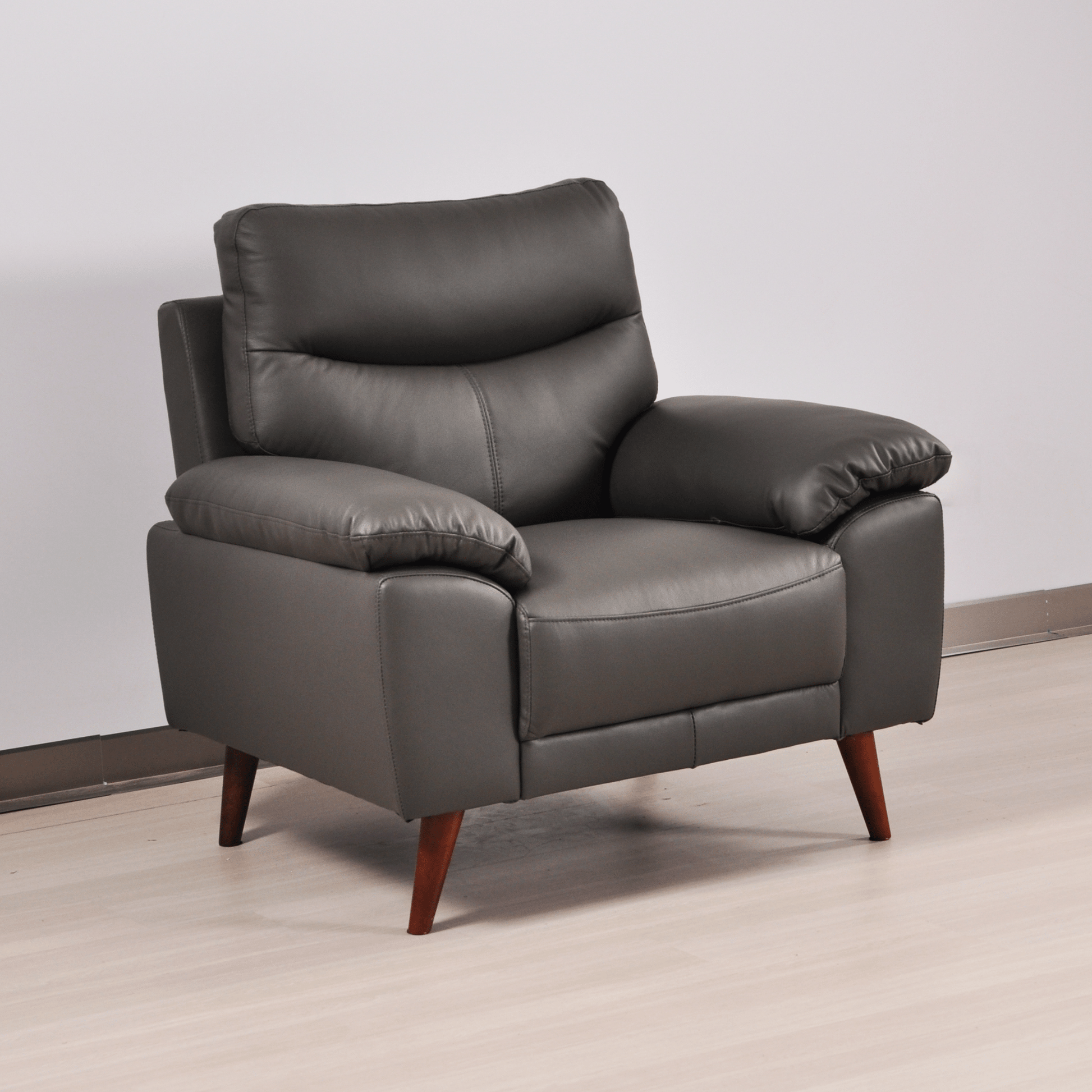 Vantage Grey Armchair angled view in living room set, highlighting cushions, fabric texture, and modern design details