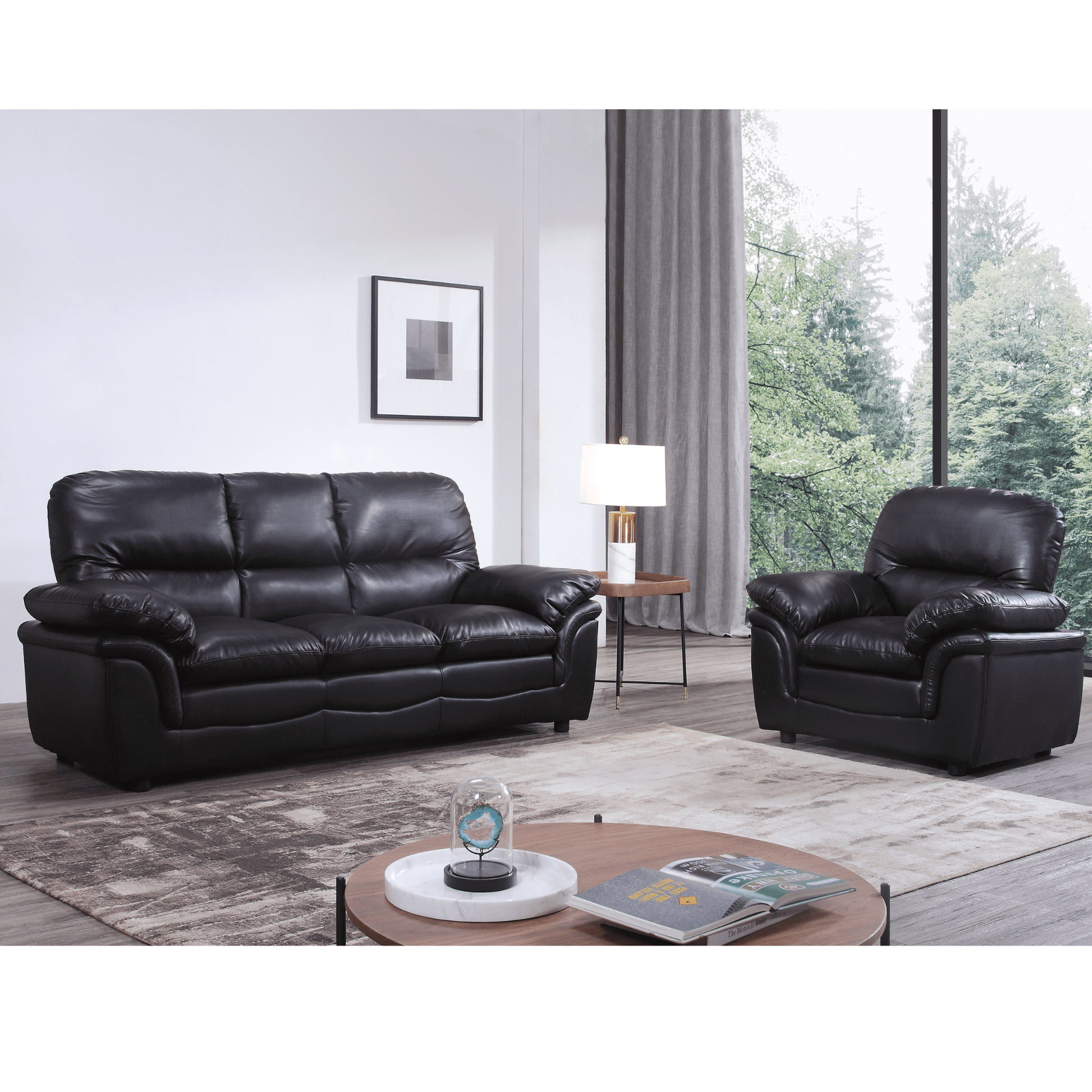 Black leather sofa set in a living room with a coffee table and decor items.