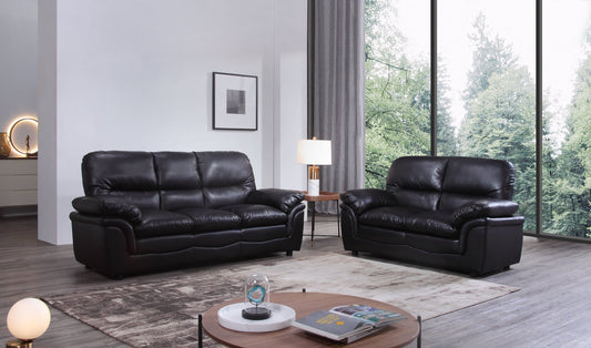 Black leather sofa set in a modern living room with large windows.