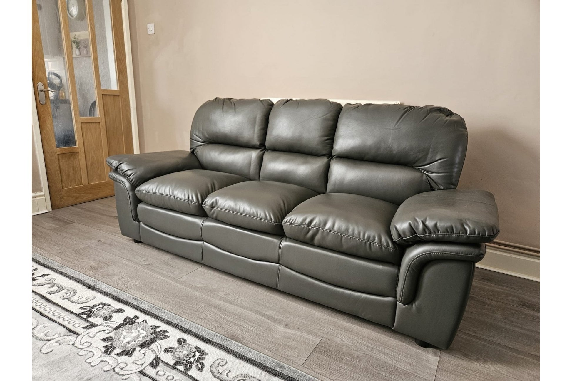 Contemporary grey leather three-seater sofa for modern living rooms, displayed on a white background