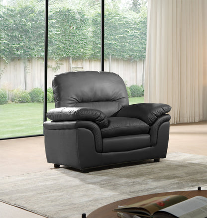 Black leather recliner chair in a room with large windows and a rug.