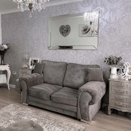 Gray sofa in a living room with decorative elements and wallpaper.