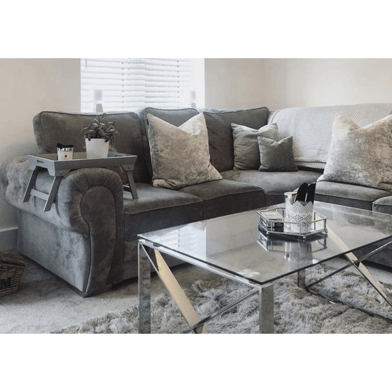 Living room with a gray sectional sofa and glass coffee table.
