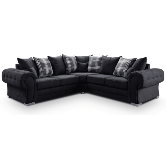 Black sectional sofa with patterned cushions on a white background