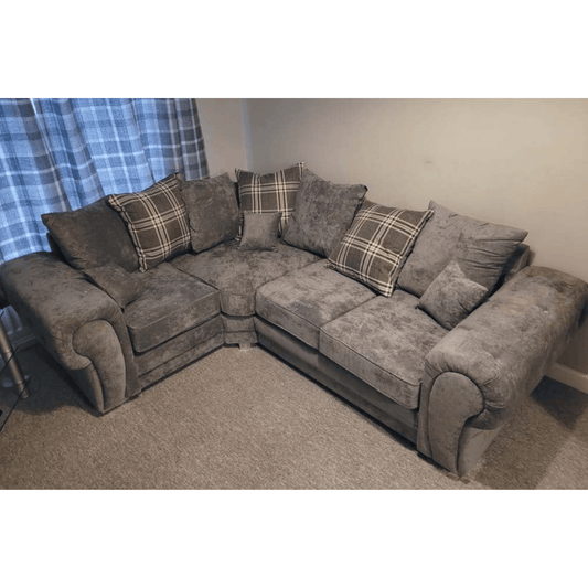 Gray sectional sofa with plaid cushions in a living room setting.
